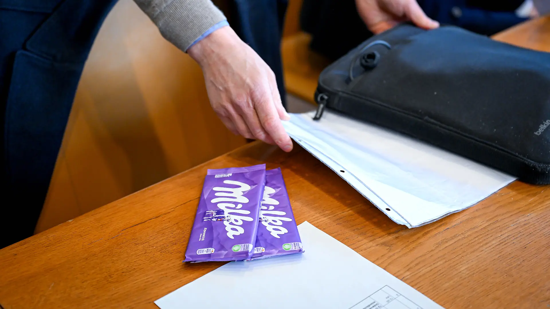 Armin Valet, Lebensmittel-Experte bei der Verbraucherzentrale mit Milka-Schokolade im Gerichtssaal. Am Landgericht Bremen beginnt das Verfahren zur „Milka”-Schokoladentafel. Die lila Packung bleibt, es ist aber weniger drin: Weil Schokoladentafeln von Milka inzwischen 90 statt bisher 100 Gramm wiegen, ziehen Verbraucherschützer vor Gericht. Die Verbraucherzentrale Hamburg reichte eine Klage wegen unlauteren Wettbewerbs gegen den Hersteller Mondelez beim Landgericht Bremen ein.