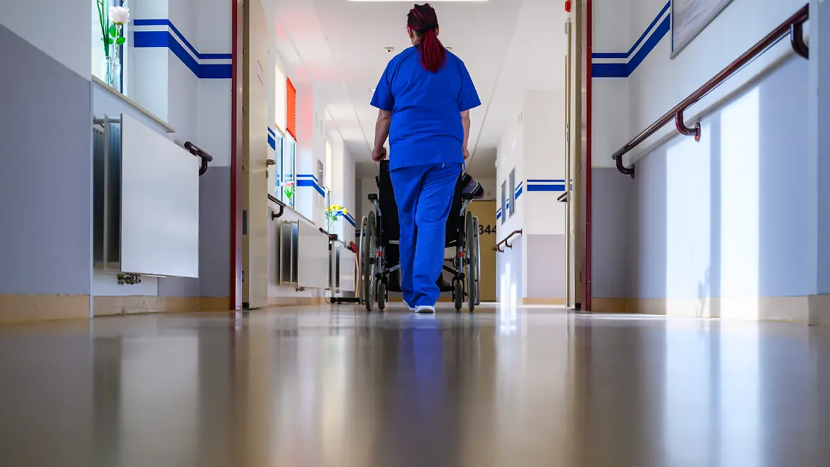 Eine Pflegerin der Geriatrie im DRK-Krankenhaus Chemnitz schiebt einen Patienten im Rollstuhl über die Station. Die Geriatrie ist auf die medizinische Versorgung älterer Patienten spezialisiert.