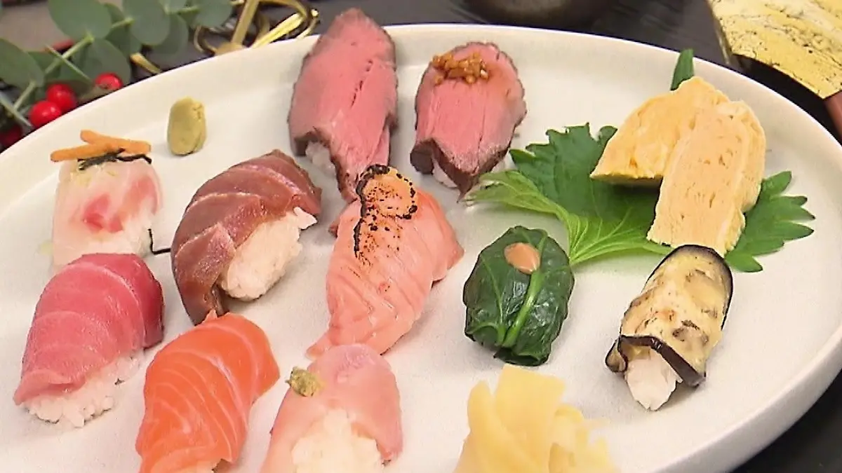 Das perfekte Dinner: Ein Teller mit kunstvoll angerichteten Sushi-Variationen mit Fleisch und Fisch