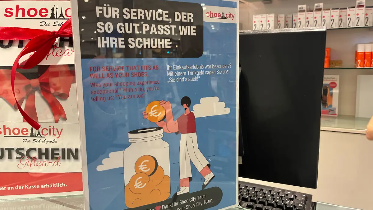 Im Schuhgeschäft weist ein Schild auf die Trinkgeld-Option hin.