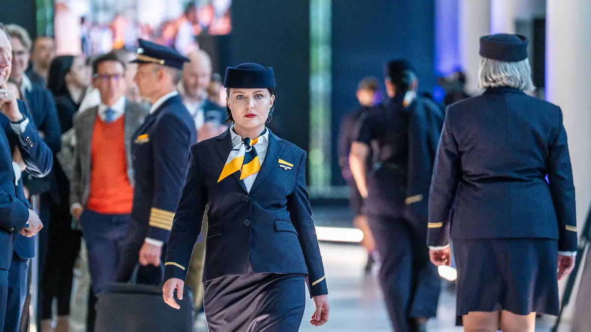 Eine Lufthansa-Flugbegleiterin präsentiert ihre neue Arbeitskleidung. Die Kranich-Airline hat im «Hangar One» zwischen historischen Lufthansa-Maschinen ihre neuen Uniformen präsentiert.