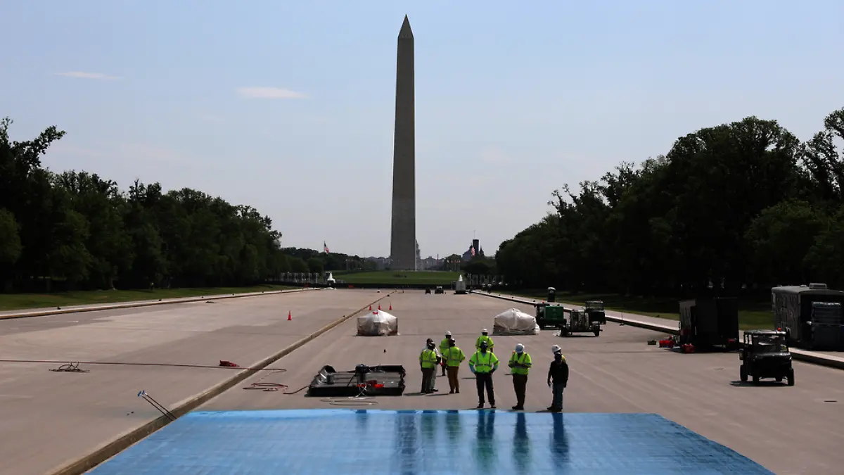 Work begins to coat the Lincoln Memorial Reflecting Pool in a blue-hued swimming pool surface Friday, April 24, 2026, on the National Mall in Washington. (AP Photo/Rahmat Gul)