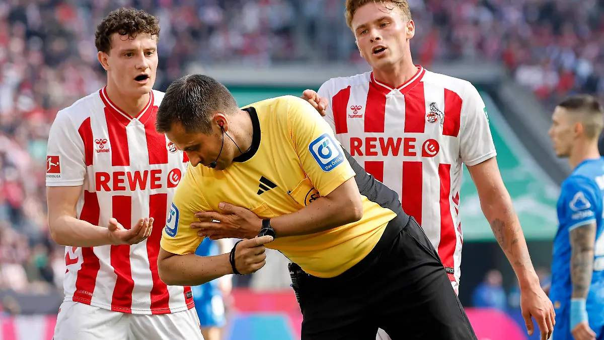 Köln, Deutschland, 1. Fussball Bundesliga Saison 2025 / 2026 31.Spieltag 1.FC Köln vs. Bayer Leverkusen 1:2 am 25. 04. 2026 im Rhein Energie -Stadion in Köln Schiedsrichter SR. Robert HARTMANN 2.v.re.- zeigt zum Unverständnis von Eric MARTEL FC li.- und Sebastian SEBULONSEN FC .re.- das Handspiel an und entscheidet auf Strafstoss Handelfmeter  *** Cologne, Germany, 1 Soccer Bundesliga Season 2025 2026 Matchday 31 1 FC Köln vs Bayer Leverkusen 1 2 on 25 04 2026 at Rhein Energie Stadium in Cologne Referee SR Robert HARTMANN 2 f right indicates the handball to the incomprehension of Eric MARTEL FC left and Sebastian SEBULONSEN FC right and decides on penalty kick hand penalty