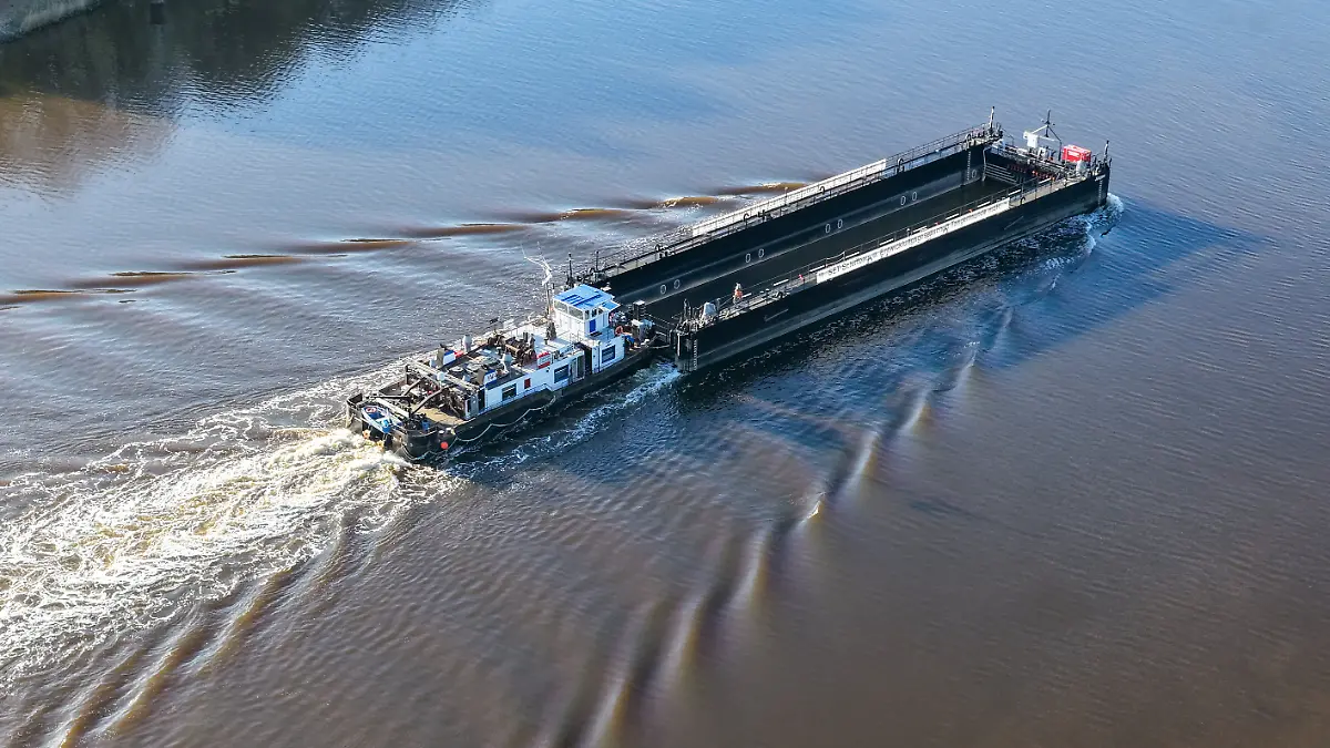 Ein Lastkahn, geschoben von dem Schubschiff «Hans» fährt auf dem Nord-Ostsee-Kanal bei Hohenhörn. Die sogenannte Barge, die für den Transport des Wals durch die Ostsee in die Nordsee vorgesehen ist, soll kommende Nacht oder Montagfrüh an der Insel Poel ankommen. (Aufnahme mit einer Drohne) (zu dpa: «Wal vor Poel – diese Woche Abtransport per Lastkahn?») +++ dpa-Bildfunk +++