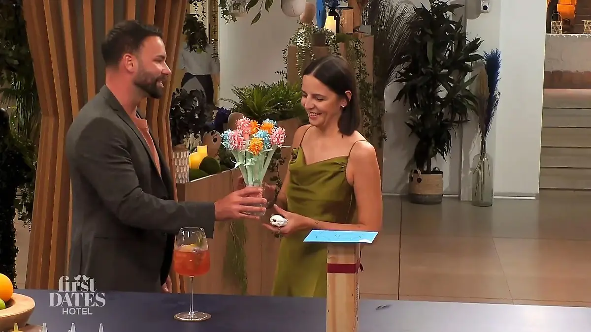 Philipp überreicht den Strauß aus bunten Papierblumen.