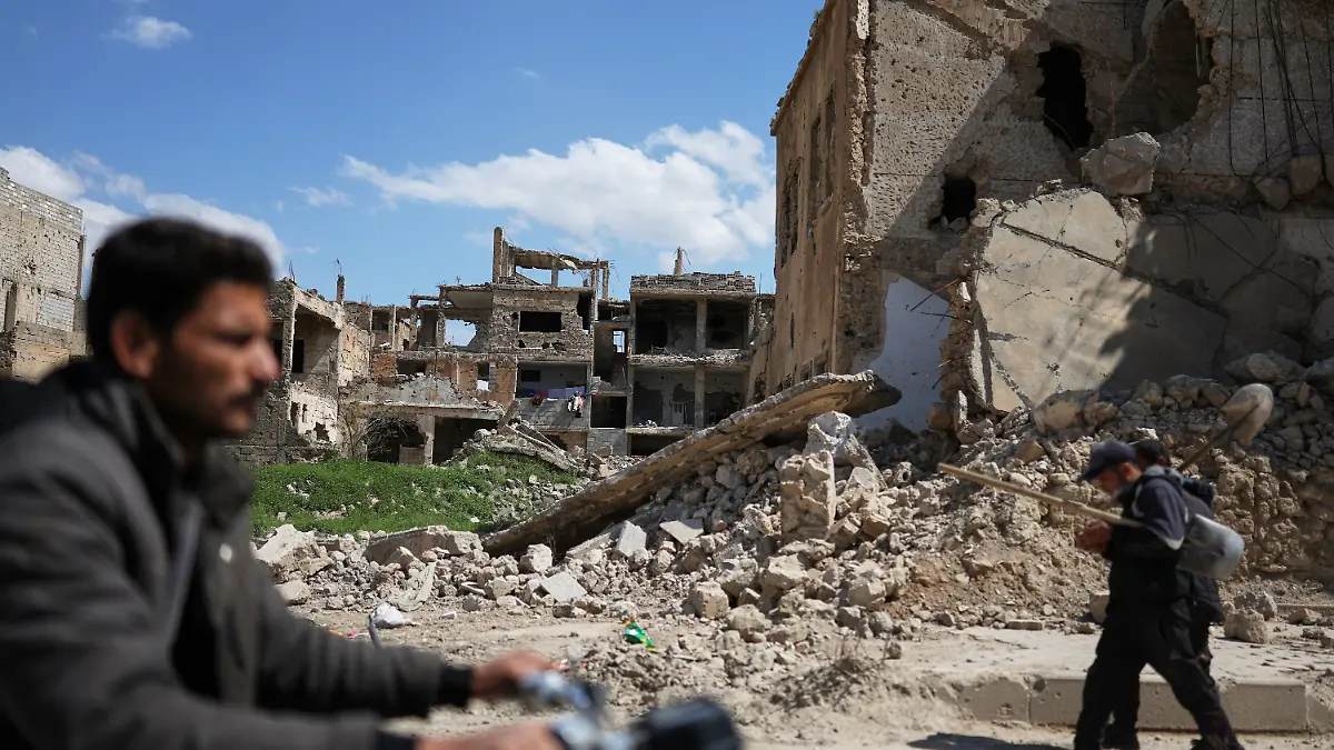 Anwohner gehen an den Ruinen von Gebäuden vorbei, die während des Krieges im Nordosten Syriens zerstört wurden. +++ dpa-Bildfunk +++