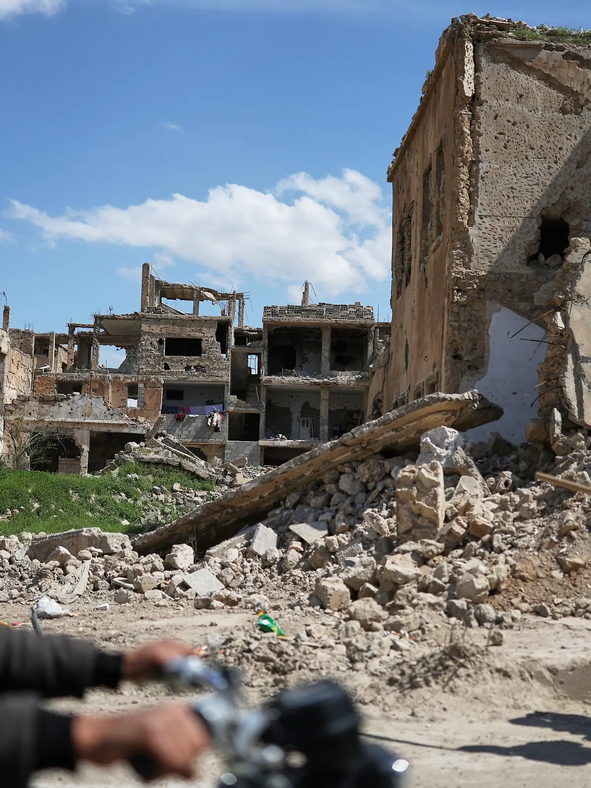 Anwohner gehen an den Ruinen von Gebäuden vorbei, die während des Krieges im Nordosten Syriens zerstört wurden. +++ dpa-Bildfunk +++