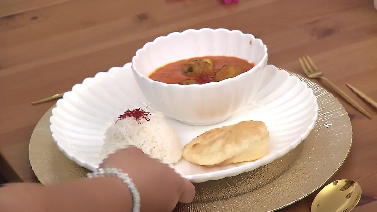 Das perfekte Dinner: Tellerbild: Schale mit Bällchen in Soße auf einem Teller, daneben Basmati-Reis und eine Teigtasche