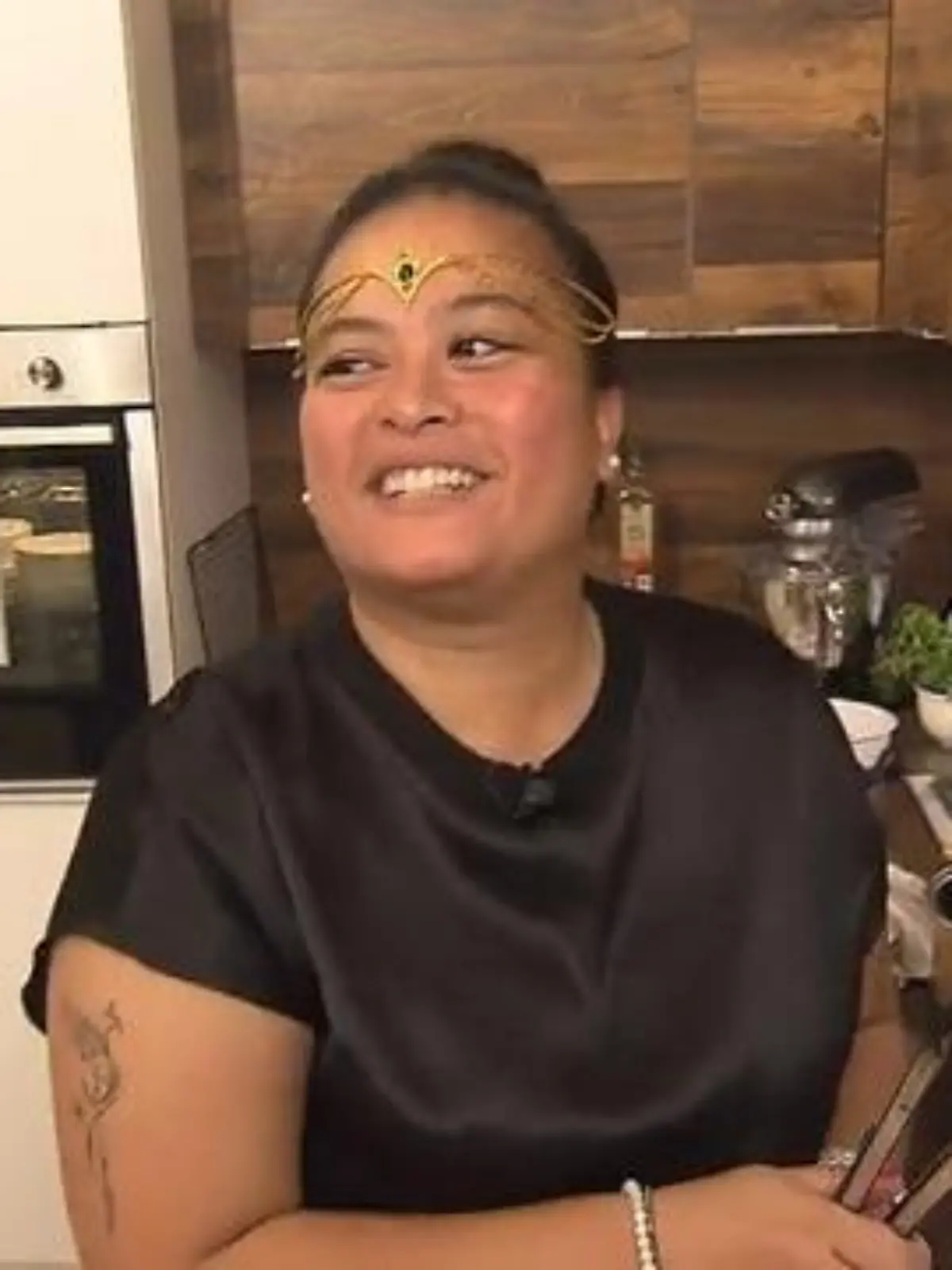 Das perfekte Dinner: Junge Frau mit Kopfschmuck und schwarzem Oberteil in der Küche