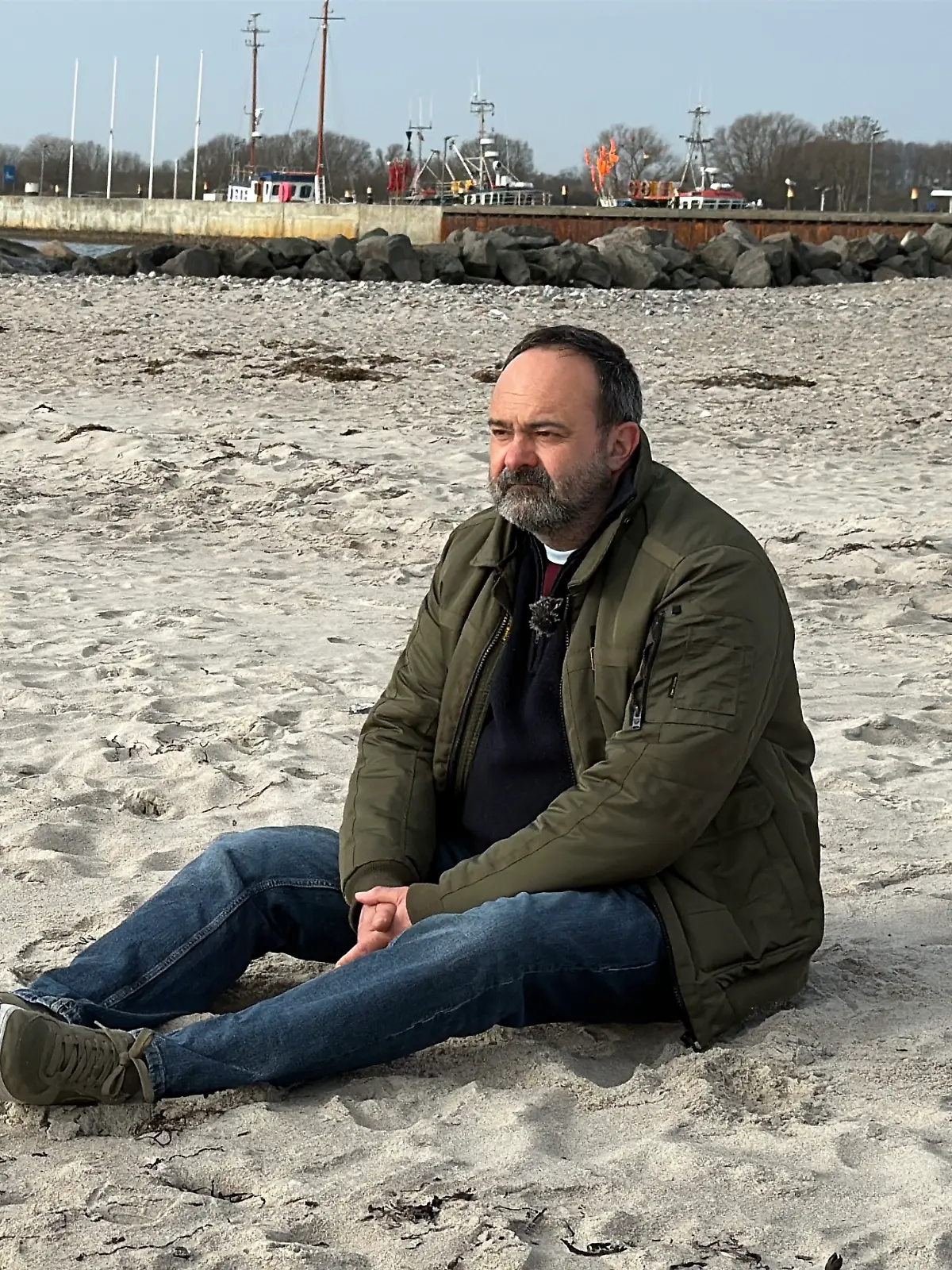 Tom Keune sitzt am Strand