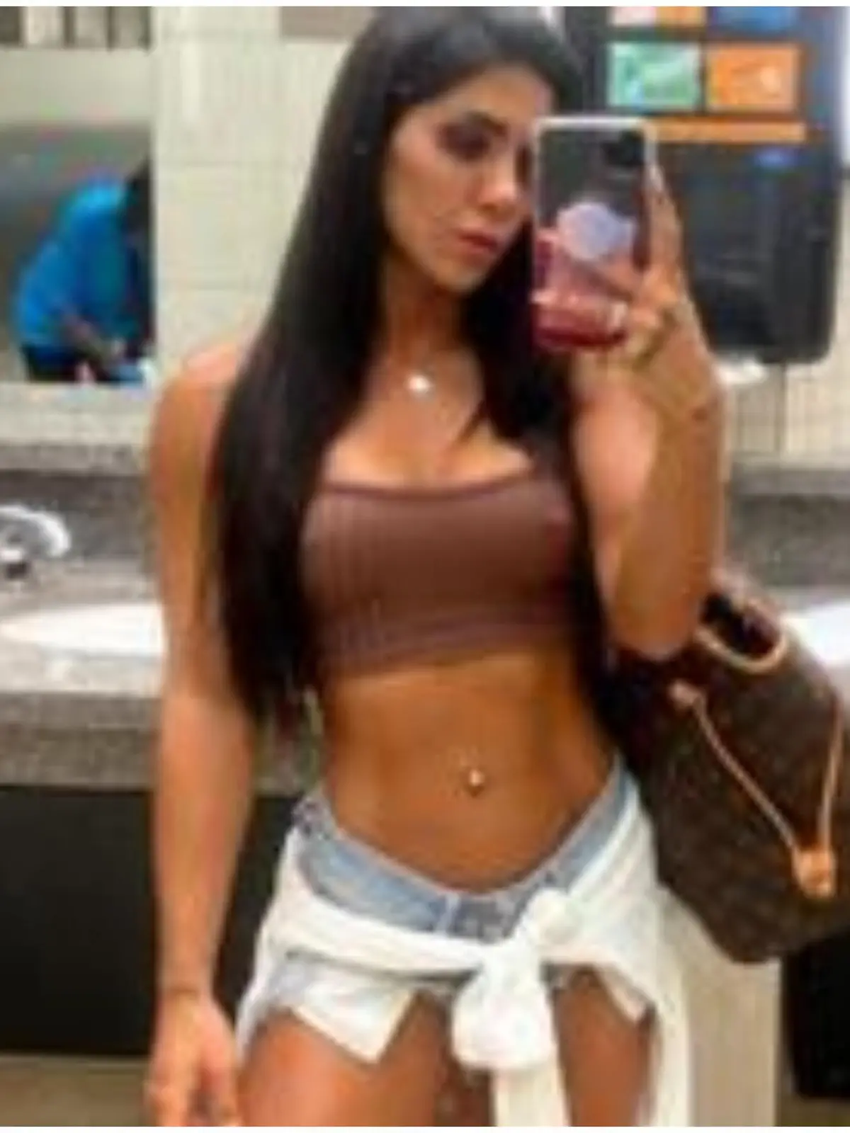 Eine Frau trägt eine Shorts und ein Croptop.