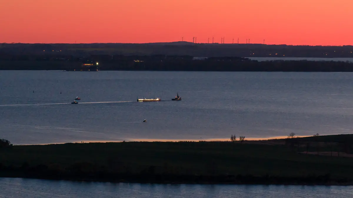Das Schiff „Robin Hood“ zieht am Abend vor Wismar die Barge mit dem gestrandetem Wal in Richtung Ostsee (Luftaufnahme mit einer Drohne).