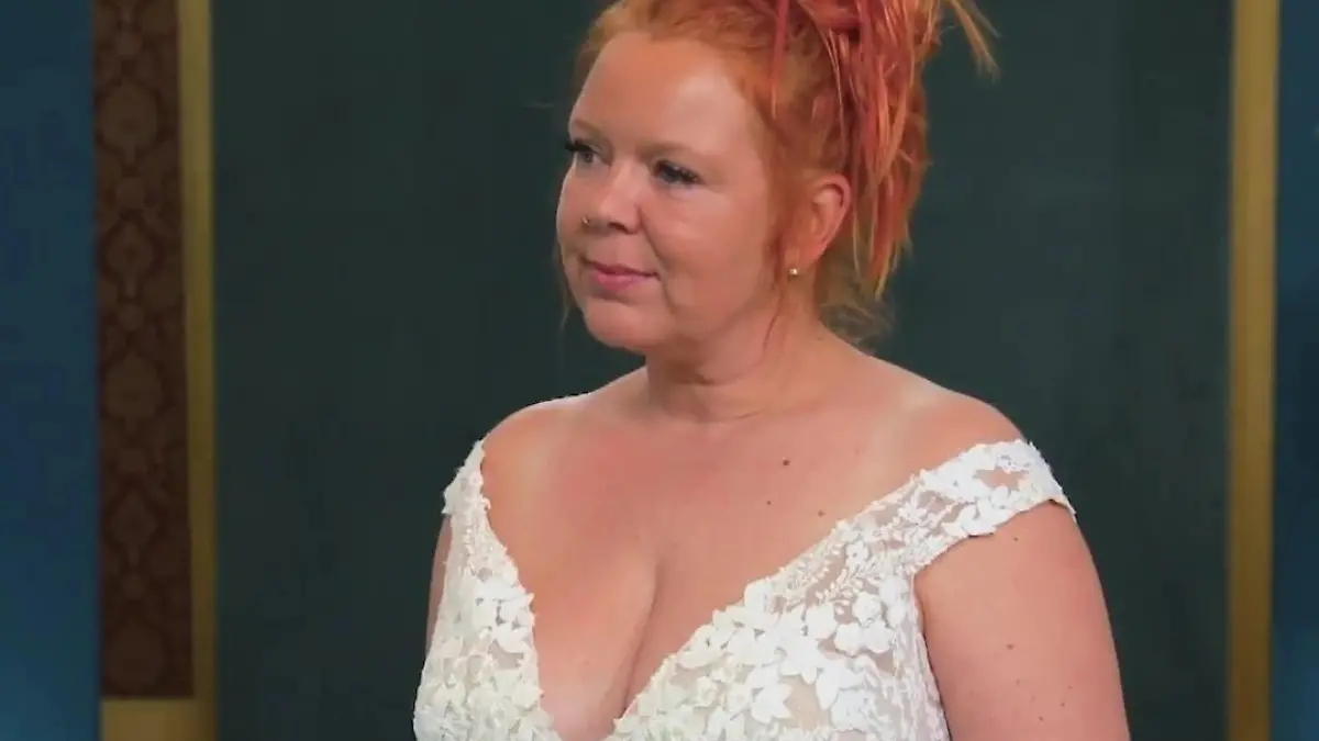 Das Duell - Zwischen Tüll und Tränen: Frau mit roten aufgesteckten Haaren in einem spitzenbesetzten, ausgeschnittenen Brautkleid