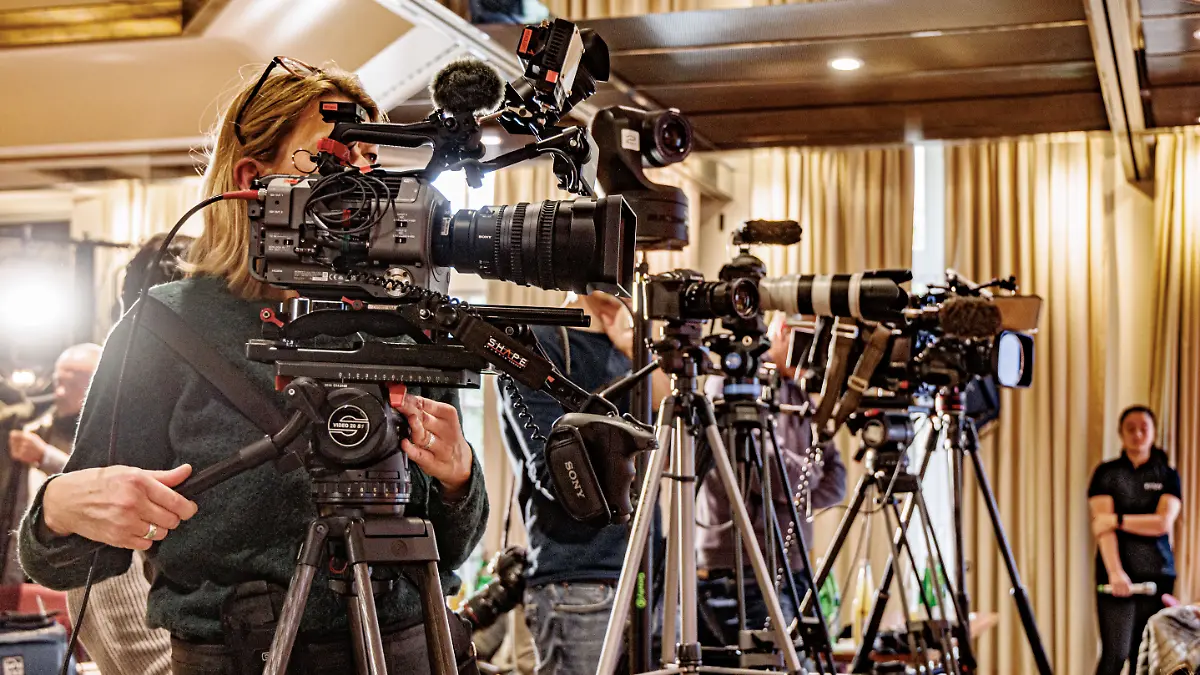 Fernseh- und Videokameras stehen vor dem Podium einer Pressekonferenz.