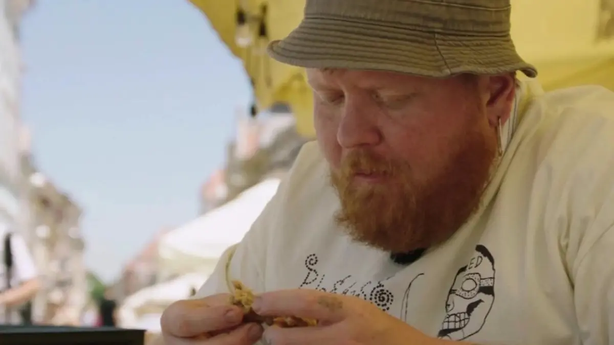 Lukas Mraz sitzt am Tisch, betrachtet Essen vor sich.