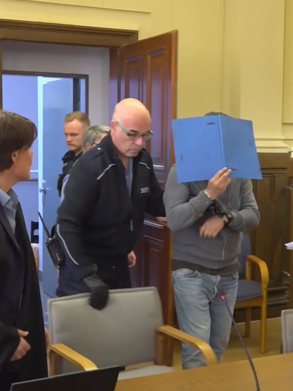 Kemal A. (mit Aktenmappe in der Mitte) steht wegen eines Messerangriffs vor Gericht