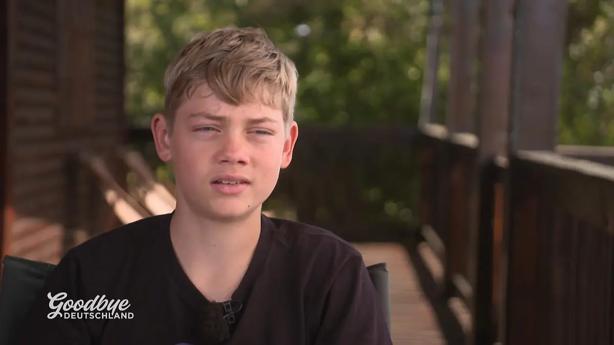 Goodbye Deutschland: Junge in schwarzem T-Shirt in Nahaufnahme