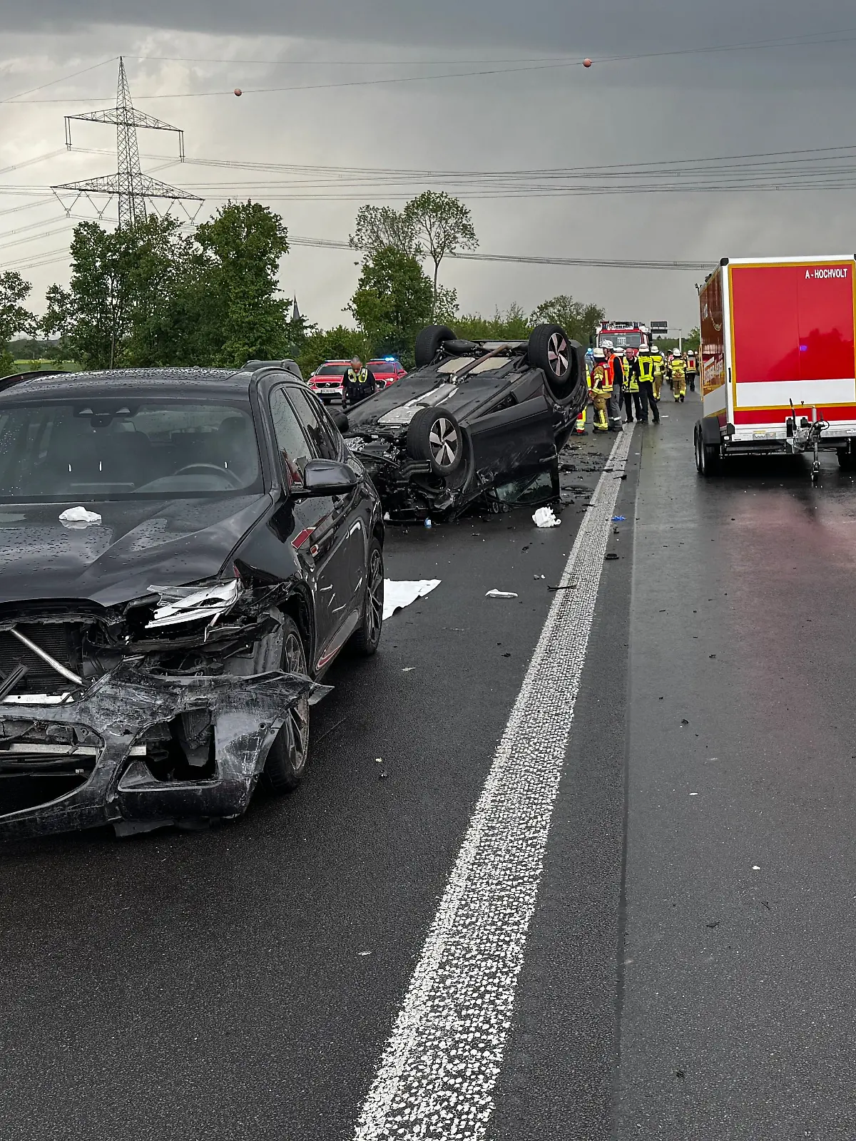 Drei beschädigte Fahrzeuge stehen nach einem Verkehrsunfall auf der Autobahn A61 zwischen Feuerwehrfahrzeugen. Bei einem schweren Verkehrsunfall auf der Autobahn 61 in Nordrhein-Westfalen bei Kerpen nahe Köln ist eine Frau ums Leben gekommen - ein Kind erlitt schwere Verletzungen.