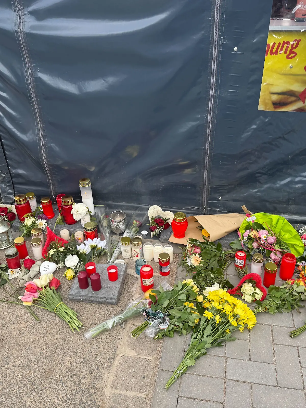 Vor dem Bratwurststand von Dana A. und Jan C. werden Blumen niedergelegt