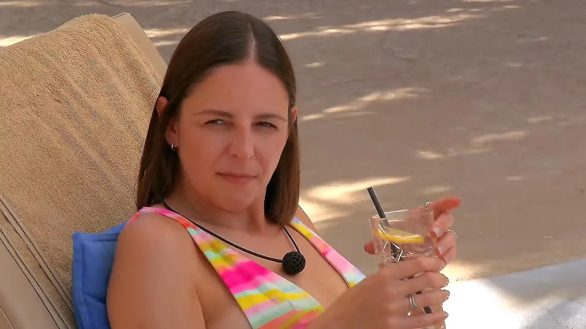Maggie mit einem Drink am Pool.