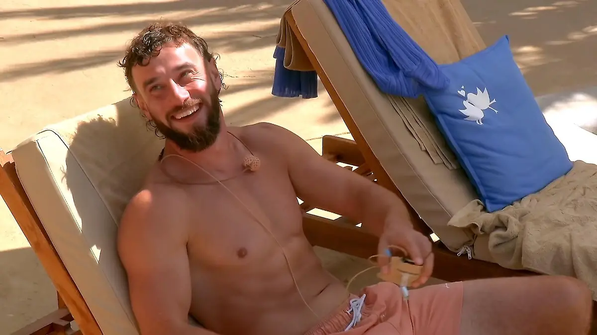 Phillip auf der Liege am Pool, lachend.