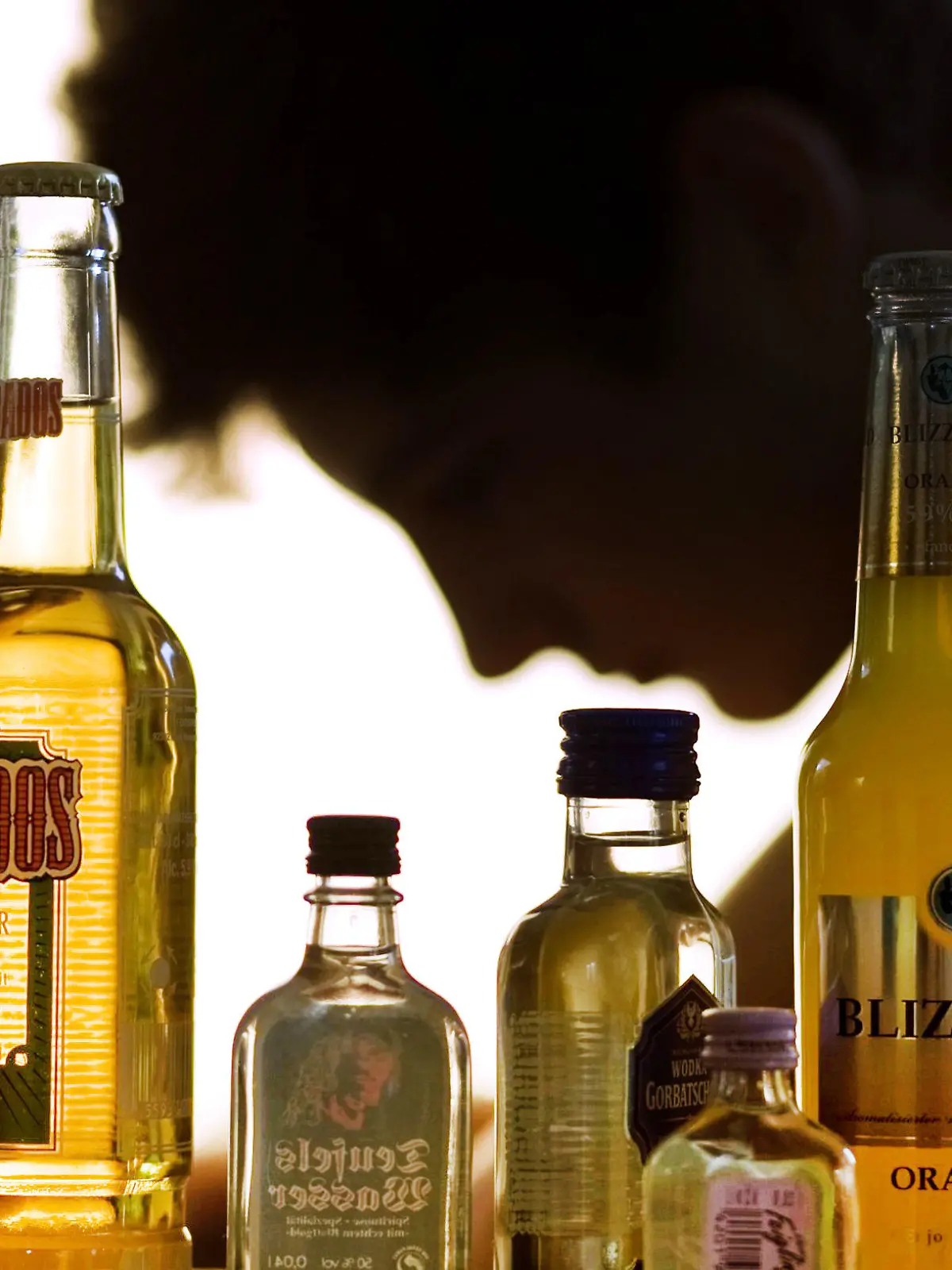 ARCHIV - Ein Jugendlicher sitzt hinter Flaschen mit Alkohol in Schwerin (Illustration vom 07.09.2009). Die nordrhein-westfälische Gesundheitsministerin Steffens stellt am Montag in Düsseldorf eine neue Initiative gegen "Komatrinken" vor.   Foto: Jens Büttner/dpa +++(c) dpa - Bildfunk+++