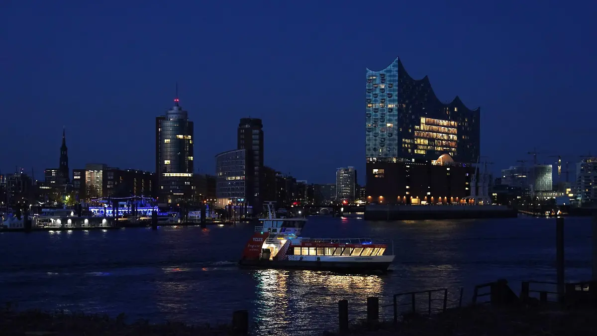 03.05.2023, Hamburg: Eine HVV-Hafenfähre fährt in der blauen Stunde auf der Elbe im Hafen. Foto: Marcus Brandt/dpa +++ dpa-Bildfunk +++