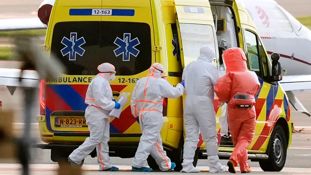 Sanitäter begleiten eine Person (2.v.r.), die mit Verdacht auf eine Hantavirus-Infektion von dem Kreuzfahrtschiff MV Hondius evakuiert wurde, zu einem Krankenwagen, nachdem diese zum Flughafen Schiphol in Amsterdam, Niederlande, geflogen worden war. +++ dpa-Bildfunk +++