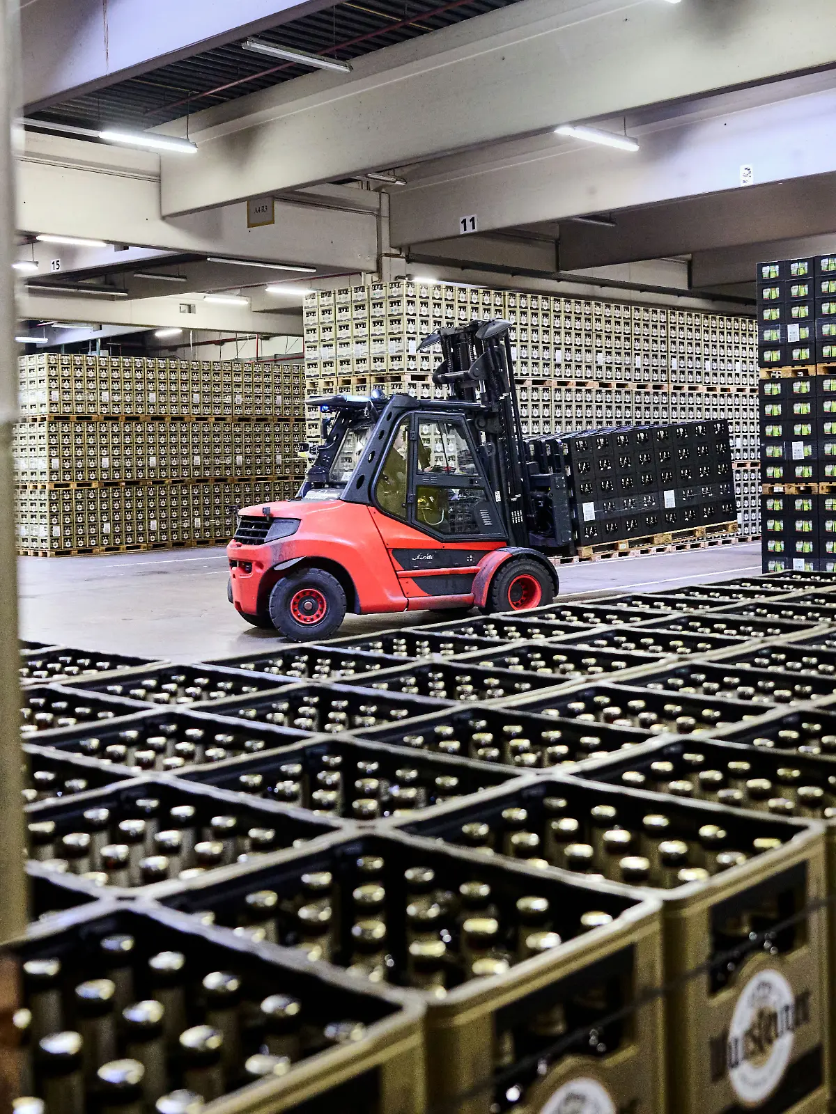 Ein Gabelstapler ist in der Logistik der Warsteiner Brauerei zwischen Bierkästen unterwegs.