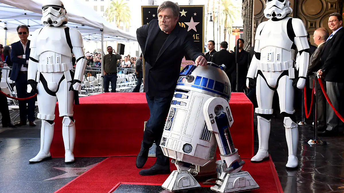 08.03.2018, USA, Los Angeles: US-Schauspieler Mark Hamill steht mit einem R2-D2 vor seinem Hollywood-Stern auf dem Walk of Fame. Schauspieler Mark Hamill, bekannt als Jedi-Ritter Luke Skywalker im «Krieg der Sterne» von 1977, ist mit einem Stern auf dem Walk of Fame in Hollywood geehrt worden. Foto: Jordan Strauss/Invision/AP/dpa +++ dpa-Bildfunk +++