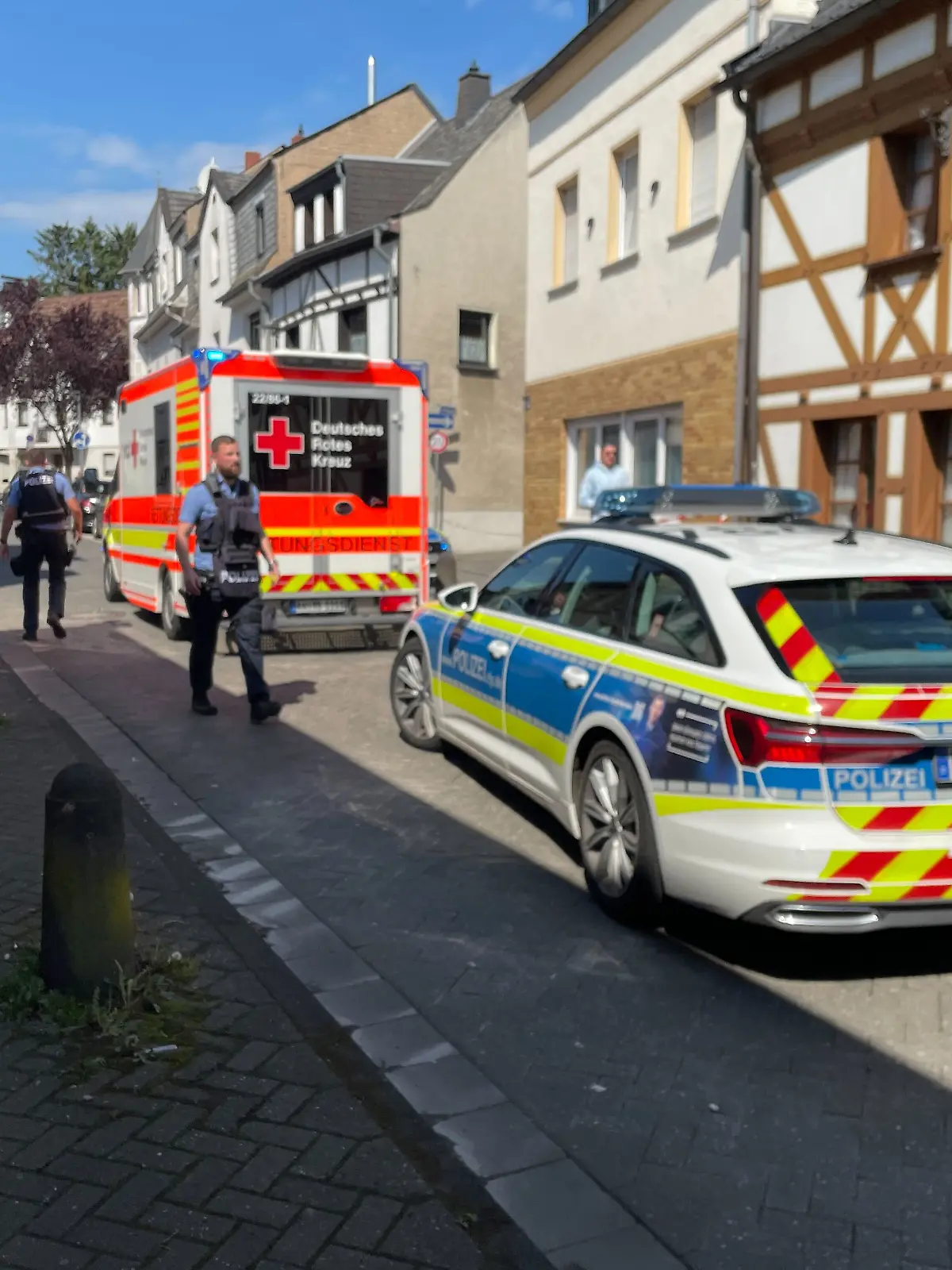 Geiselnahme in Sinzig: Die Polizei hat den Bereich um die Volksbank weiträumig abgeriegelt. Rettungskräfte stehen bereit.