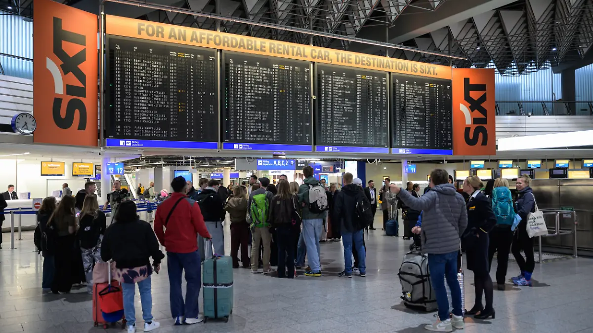 Menschen stehen vor einer Anzeigetafel mit gestrichenen Flügen der Lufthansa am Frankfurter Flughafen. Die Pilotengewerkschaft Vereinigung Cockpit hat für Montag und Dienstag zu Arbeitsniederlegungen bei der Lufthansa und mehreren Tochtergesellschaften aufgerufen.