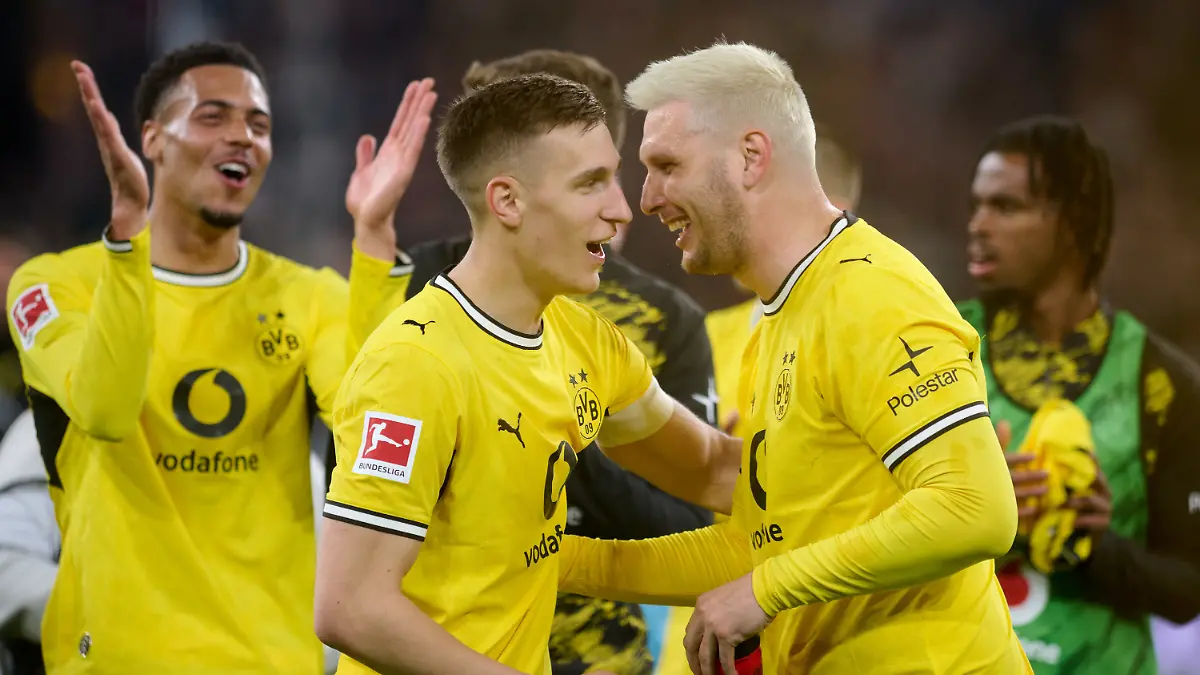 08.05.2026, Nordrhein-Westfalen, Dortmund: Fußball, Männer: Bundesliga, Borussia Dortmund - Eintracht Frankfurt, 33. Spieltag, Signal Iduna Park. Felix Nmecha (Borussia Dortmund, l-r), Nico Schlotterbeck (Borussia Dortmund) und Niklas Süle (Borussia Dortmund) freuen sich über den Sieg. Das Spiel endete 3:2. Foto: Bernd Thissen/dpa - WICHTIGER HINWEIS: Gemäß den Vorgaben der DFL Deutsche Fußball Liga bzw. des DFB Deutscher Fußball-Bund ist es untersagt, in dem Stadion und/oder vom Spiel angefertigte Fotoaufnahmen in Form von Sequenzbildern und/oder videoähnlichen Fotostrecken zu verwerten bzw. verwerten zu lassen. +++ dpa-Bildfunk +++