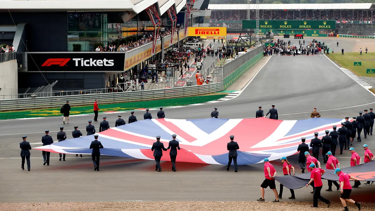 FILE PHOTO: Formula One F1 - British Grand Prix - Silverstone Circuit, Silverstone, Britain - July 14, 2019 General view of a Union Jack flag being carried out on to the track by service personnel before the race REUTERS/John Sibley/File Photo