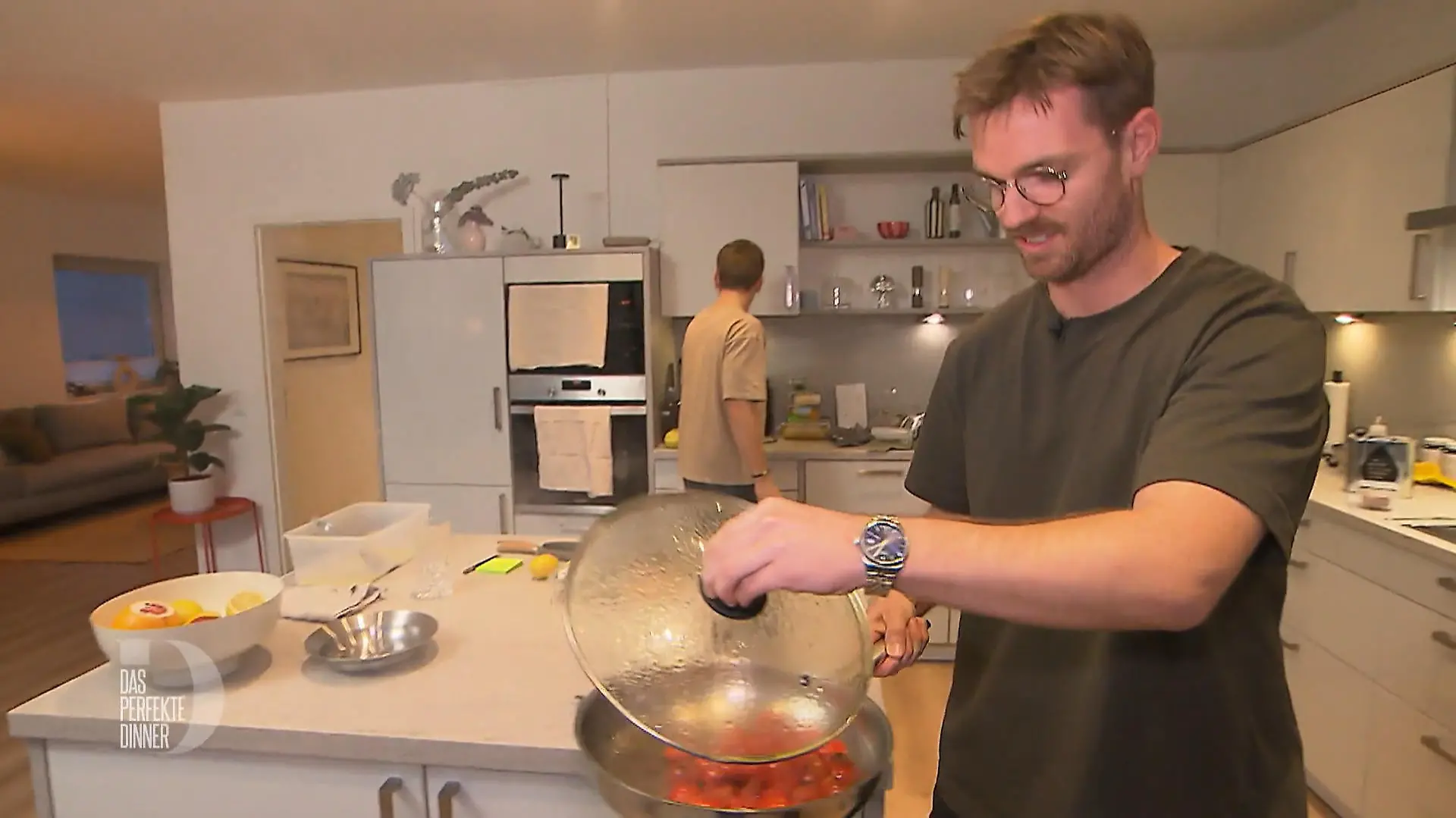 Das perfekte Dinner: Gastgeber Patrick steht mit einer Pfanne mit dampfenden Tomaten in der Hand in seiner Küche