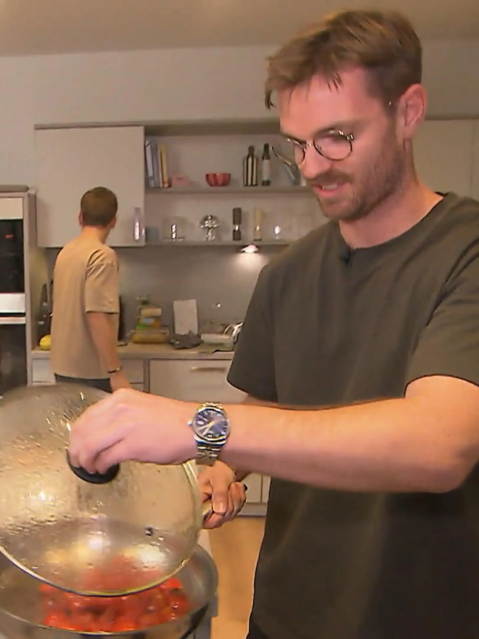 Das perfekte Dinner: Gastgeber Patrick steht mit einer Pfanne mit dampfenden Tomaten in der Hand in seiner Küche