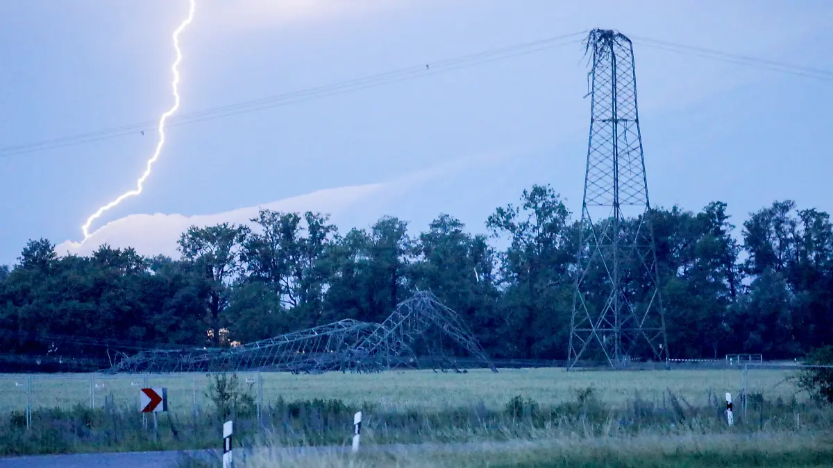 Ein Blitz entlädt sich in Nauwalde, einem Ortseil von Gröditz, hinter einem umgeknickten Strommast. Heftige Niederschläge und starke Windböen sind am Dienstagnachmittag über Teile Sachsens hinweggezogen.