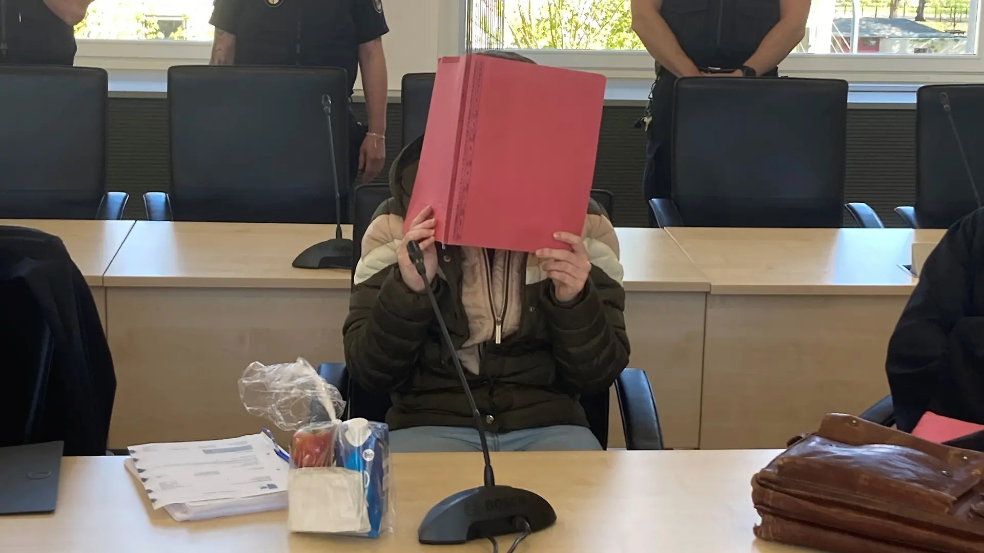 Die 30-jährige Angeklagte im Fall Fabian in Rostock hält sich im Gericht einen Ordner vors Gesicht. Vor dem Rostocker Landgericht ist der Prozess gegen eine 30-jährige Frau fortgesetzt worden, die im Oktober 2025 den achtjährigen Fabian aus Güstrow getötet haben soll.
