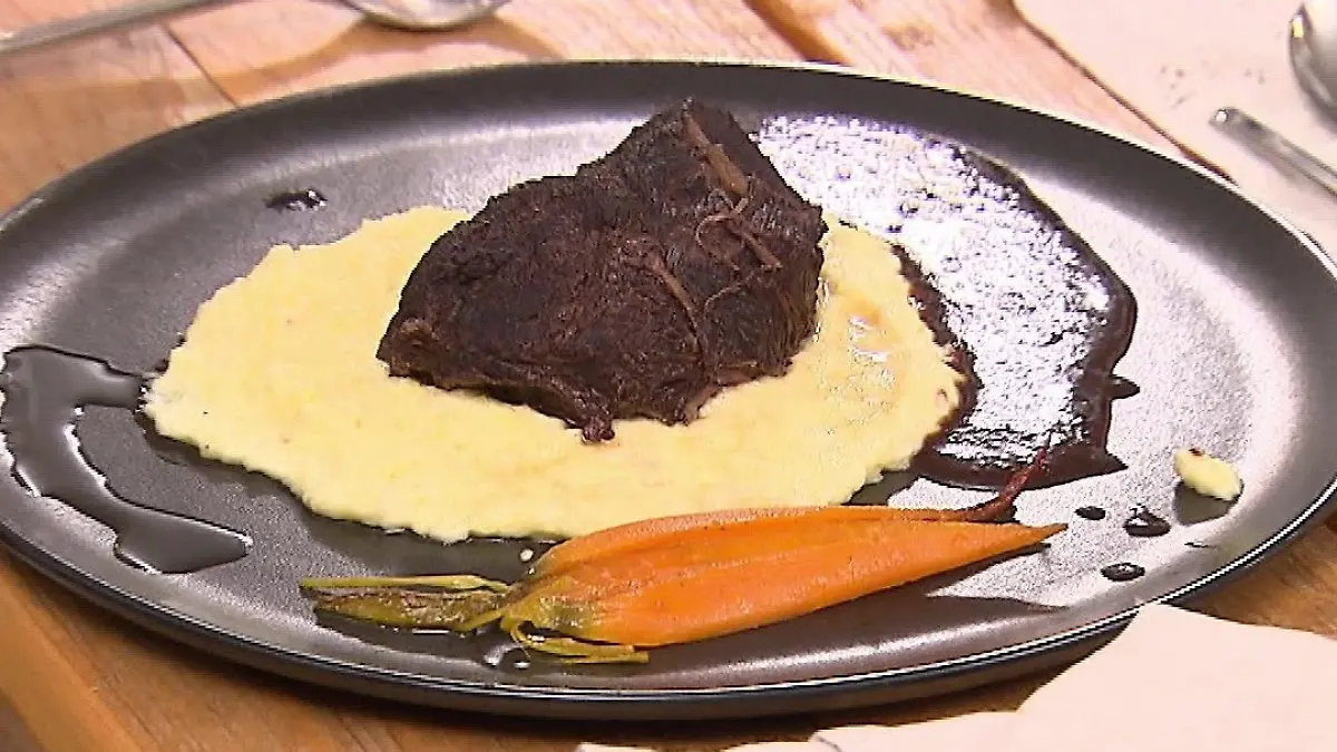 Das perfekte Dinner: Hauptgericht des Abends auf einem Teller: Kartoffelpüree, darauf Ochsenbäckchen und daneben Karotten