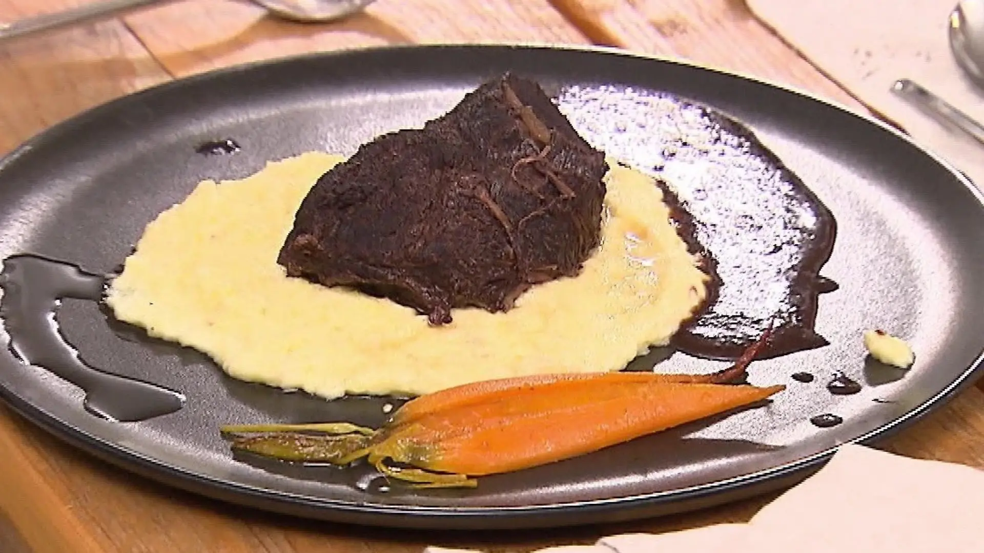 Das perfekte Dinner: Hauptgericht des Abends auf einem Teller: Kartoffelpüree, darauf Ochsenbäckchen und daneben Karotten