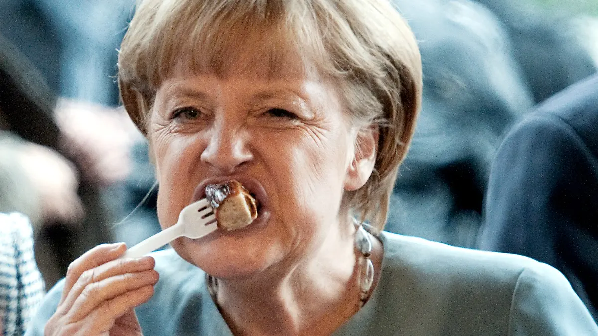 Bundeskanzlerin Angela Merkel (CDU) probiert am 24.09.2012 in Berlin eine Rostbratwurst. Die Thüringer Landesvertretung hat zum Jahresfest mehr als 1000 Gäste aus Wirtschaft und Politik geladen. Foto: Robert Schlesinger/dpa ++ +++ dpa-Bildfunk +++