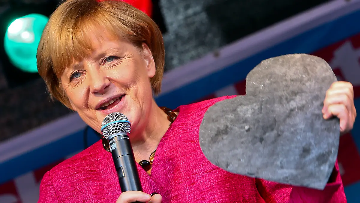 ARCHIV - Bundeskanzlerin Angela Merkel (CDU) hält am 21.09.2013 auf dem Marktplatz in Stralsund (Mecklenburg-Vorpommern) ein aus Schieferstein geschlagenes Herz. Einen Tag vor der Bundestagswahl will Merkel nochmals die Wähler in ihrem Wahlkreis mobilisieren. Foto: Jens Büttner/dpa (zu dpa-lmv Jahreschronik 2013 vom 13.12.2013) +++ dpa-Bildfunk +++