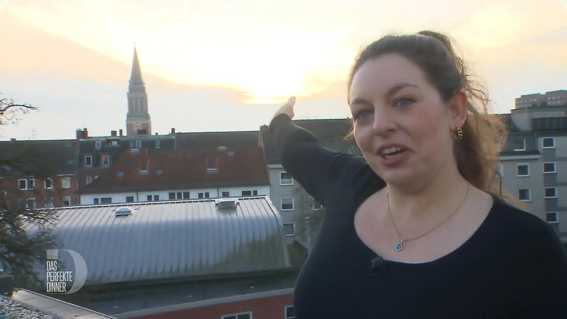Das perfekte Dinner: Gastgeberin Jessica steht auf einer Terrasse und zeigt auf die Aussicht
