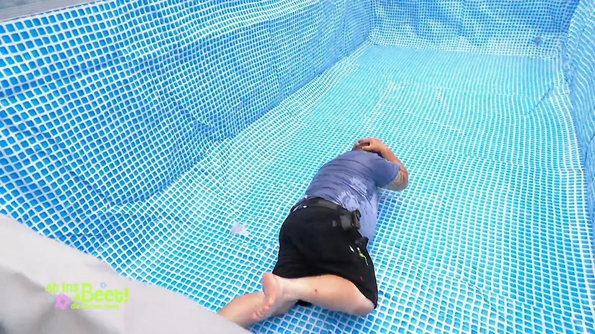 Ab ins Beet: Michel dreht sich im noch leeren Pool auf den Bauch und hält sich die Hände an den schmerzenden Kopf