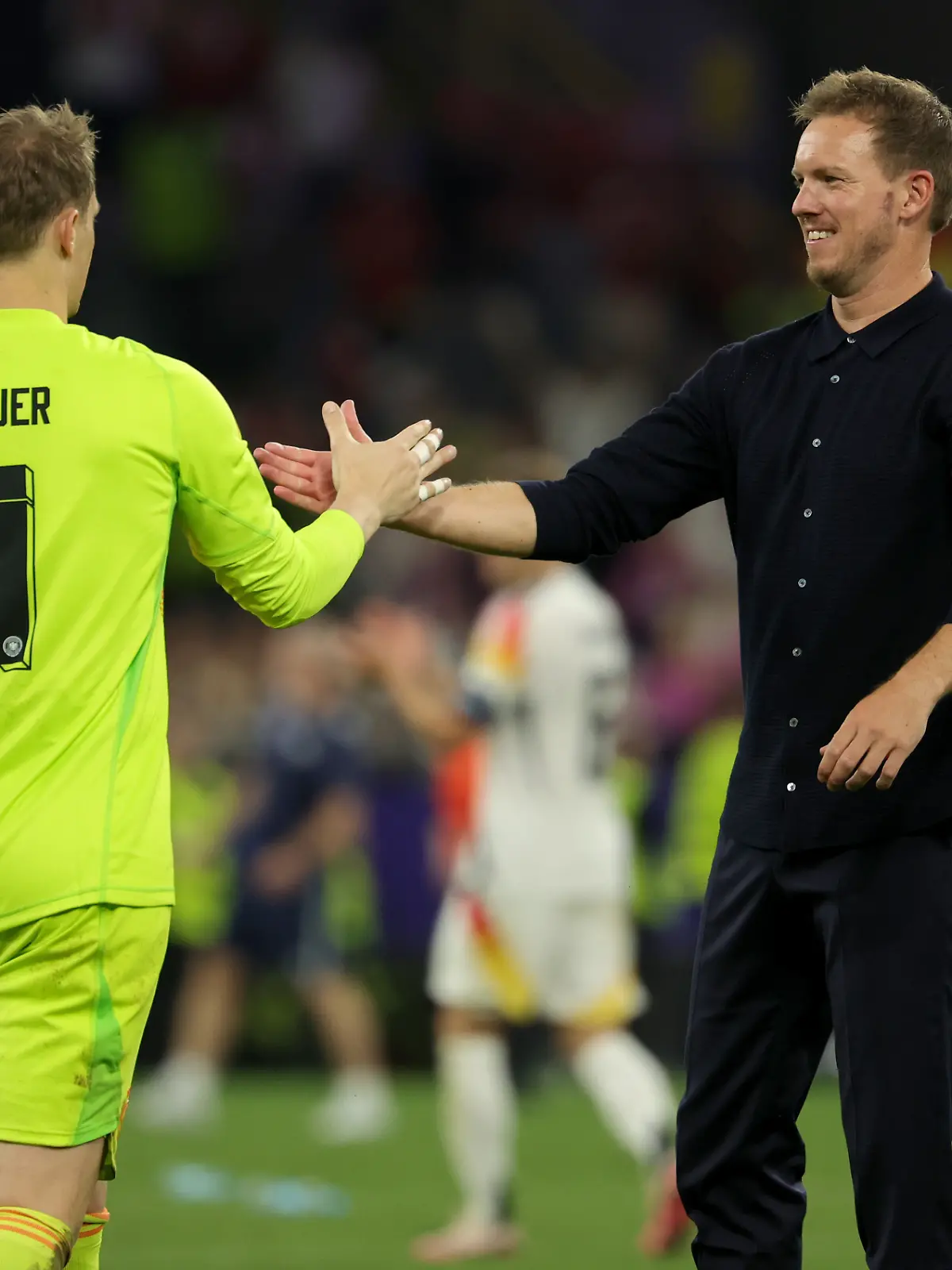 Fußball, UEFA Euro 2024, EM, Deutschland - Dänemark, Finalrunde, Achtelfinale, Stadion Dortmund, Bundestrainer Julian Nagelsmann (r) und Torhüter Manuel Neuer geben sich nach dem Spiel die Hand. (zu dpa: «Nagelsmann zu Neuer: «Torwartspiel geprägt wie kein anderer»») +++ dpa-Bildfunk +++
