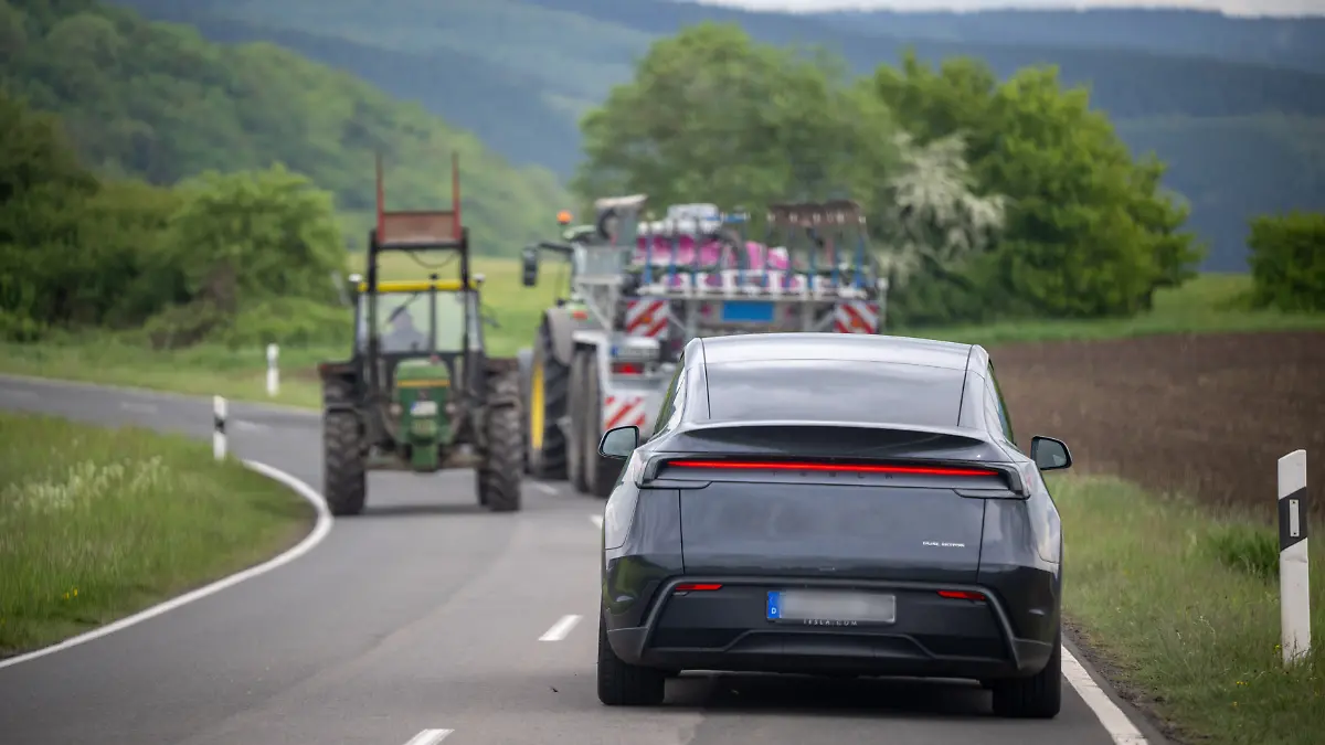 Ein selbstfahrender Tesla Modell Y ist autonom auf den Straßen der Eifel unterwegs. Ein am Steuer sitzender Werksfahrer greift bei Bedarf in das Software-Update «Full Self-Driving» (FSD/Überwacht) ein, das bundesweit noch nicht zugelassen ist.