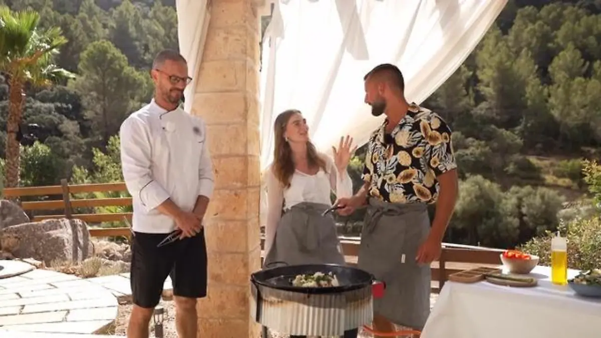 First Dates Hotel: Sarah und Adrian stehen neben einem Koch an einer Paella-Pfanne und kochen gemeinsam