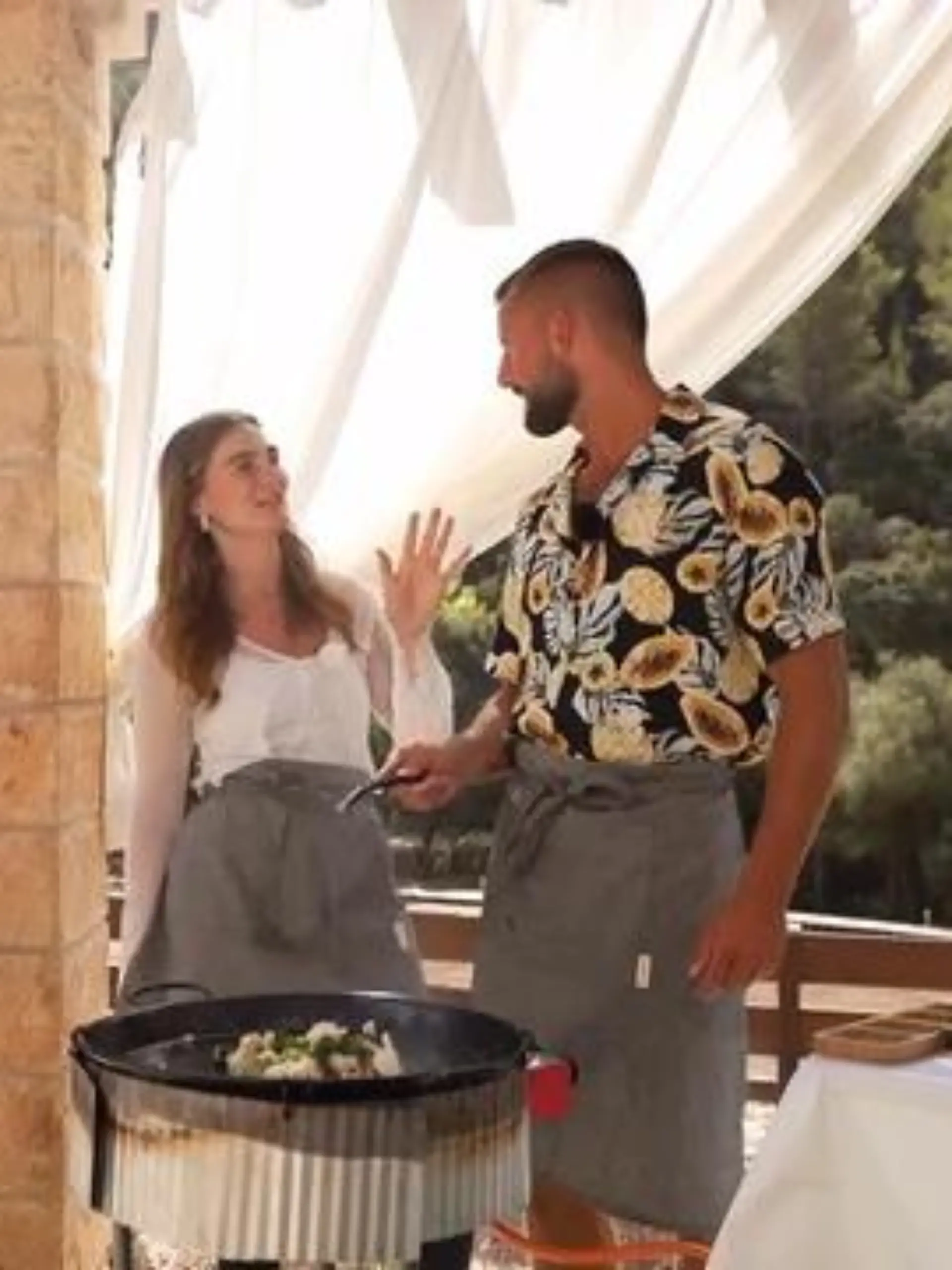 First Dates Hotel: Sarah und Adrian stehen neben einem Koch an einer Paella-Pfanne und kochen gemeinsam