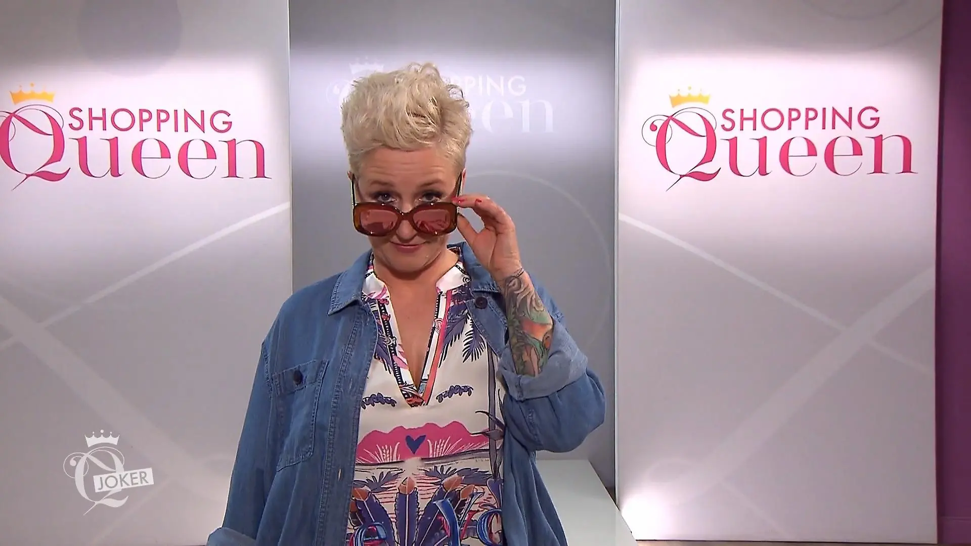 Sabine auf dem Laufsteg, blickt in die Kamera und zieht ihre Sonnenbrille leicht herunter.