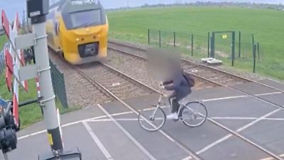 Bild von Lebensgefahr auf Bahnübergang! Teenager radelt seelenruhig vor heranrasenden Zug